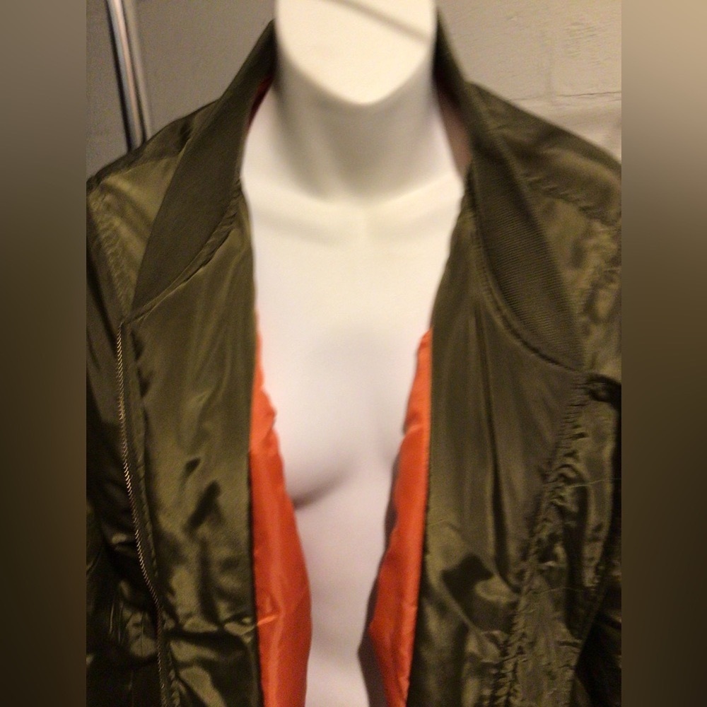 Olive shiny bomber jacket with orange lining.
